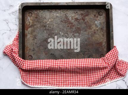 empty rectangular iron baking sheet on white marble table Stock Photo