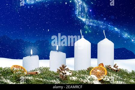 two candles on an advent wreath burns with wintery background Stock Photo