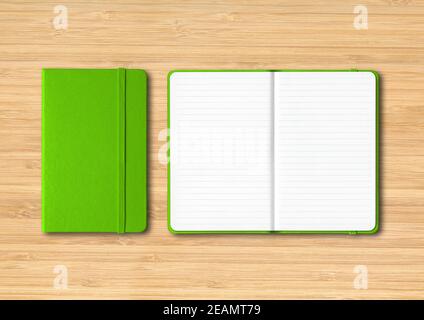 Green closed and open lined notebooks on wooden background Stock Photo