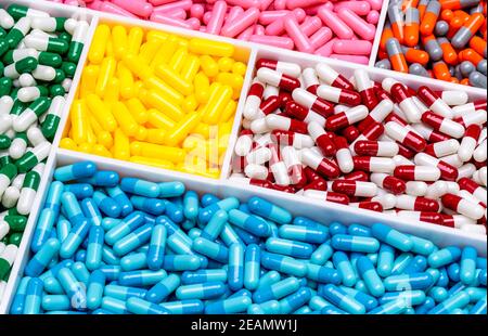 Top view of colorful capsule pills in plastic tray. Pharmaceutical industry. Healthcare and medicine. Drug production. Pharmaceutics concept. Vitamins and supplements capsules. Bright color capsule. Stock Photo