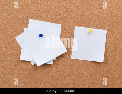 white square blank pieces of paper pinned on a cork board Stock Photo