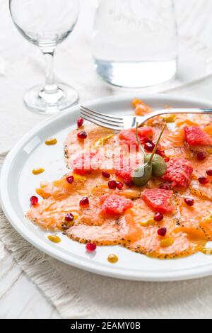 Salmon carpaccio with pink grapefruit and pomegranate Stock Photo