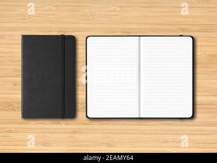 Black closed and open lined notebooks on wooden background Stock Photo