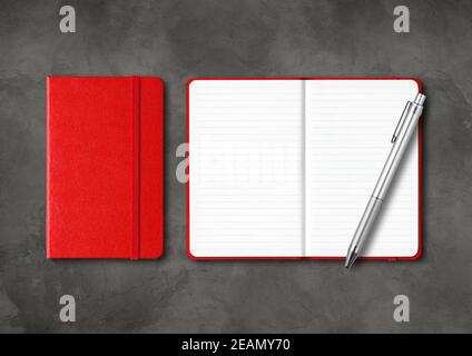 Red closed and open lined notebooks with a pen on dark concrete background Stock Photo