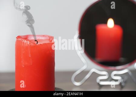 Concept photo of a extinct candle that is not reflected in the mirror.Christmas divination and spirituality.Religion and divine.Psychology,motivation.Power of thought.Never give up,go for your goals. Stock Photo