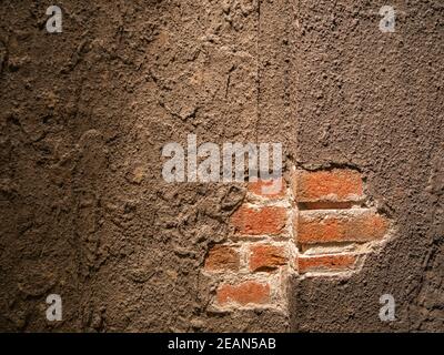 A fallen plaster on a red brick wall Stock Photo