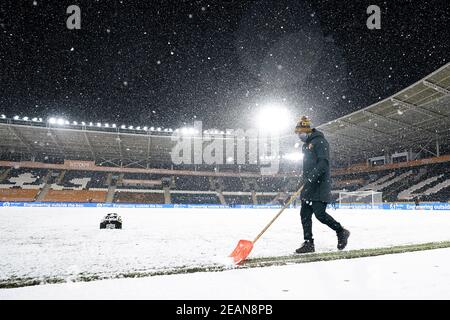 A general view of a groundsman clearing snow from the pitch before the Sky Bet League One match at KCOM Stadium, Hull. Picture date: Tuesday February 9, 2021. Stock Photo