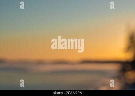 Defocus. Sunset over the sea in winter, frozen sea. Photo for background, space for text. High quality photo Stock Photo