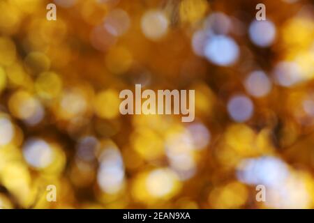 Glittering blurred olden and white background with luminous dots Stock Photo