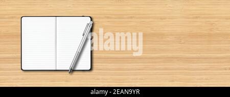 Black open lined notebook with a pen isolated on wooden background. Horizontal banner Stock Photo