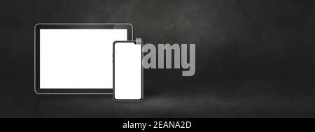 Mobile phone and digital tablet pc on dark concrete office scene. Background banner Stock Photo