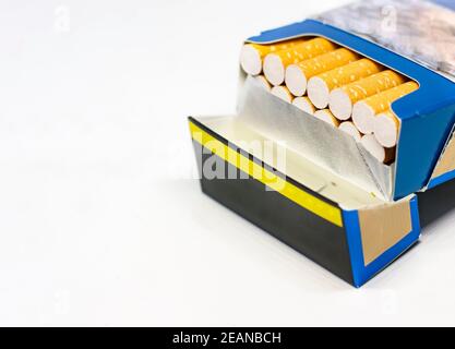 Group of cigarettes inside an open blue packet isolated on a white background. Stock Photo