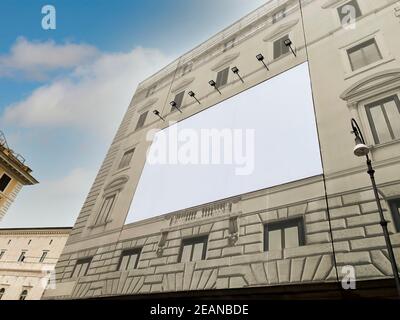 Blank advertising billboard on the scaffolding of the facade of an ancient building under restoration Stock Photo