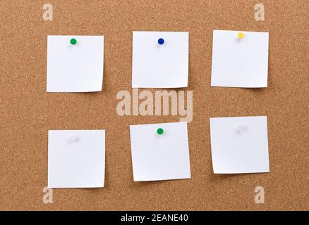 white square blank pieces of paper pinned on a cork board Stock Photo