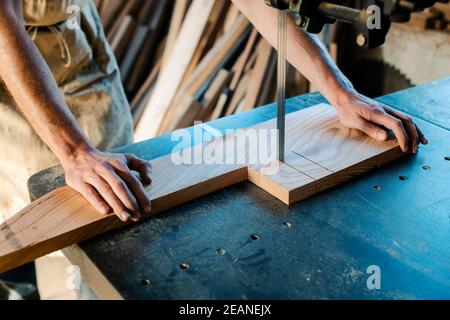 Carpenter using band saw to cut out piece of wood Stock Photo