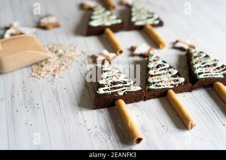 Homemade decorated chocolate brownies in shape of Christmas tree on wood table background, Italy, Europe Stock Photo
