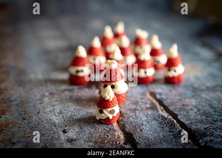 Close-up of cute strawberries shaped as Santa Claus filled with whipped cream and chocolate pieces for Christmas, Italy, Europe Stock Photo