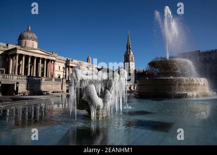 London, UK. 10th Feb, 2021. Photo taken on Feb. 10, 2021 shows icicles around sculptures on the fountain at Trafalgar Square in London, Britain. Storm Darcy has brought snows in London for several days. Credit: Han Yan/Xinhua/Alamy Live News Stock Photo