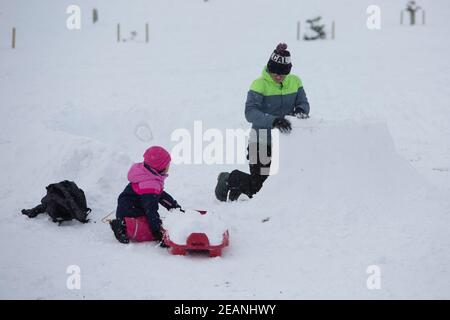 Edinburgh, UK. 10th Feb, 2021. Members of the public enjoying the the sunny day in Edinburgh. Storm Darcy hits Scotland in the South East of Edinburgh. The Inch. Pictured: Members fo the public building an igloo. Credit: Pako Mera/Alamy Live News