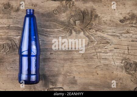 Blue glass bottle lying on an old wooden surface Stock Photo