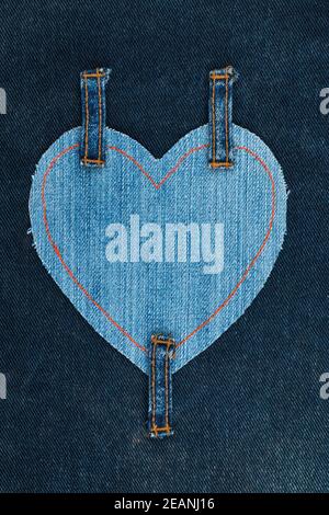 Heart made of denim fabric and attached three straps on dark Stock Photo