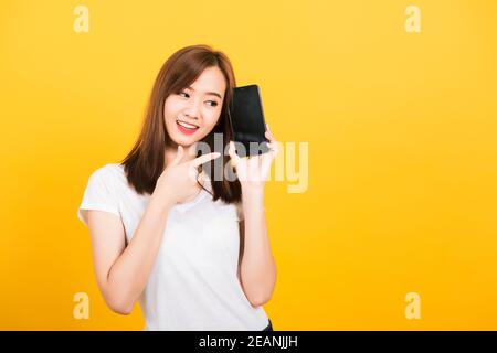 woman smile standing wear t-shirt making finger pointing on smartphone blank screen Stock Photo