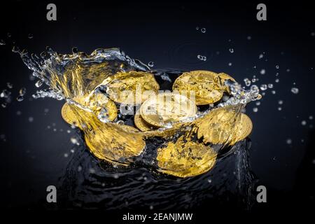 Gold bitcoin coin falling to water. Bitcoin and water splash. Stock Photo
