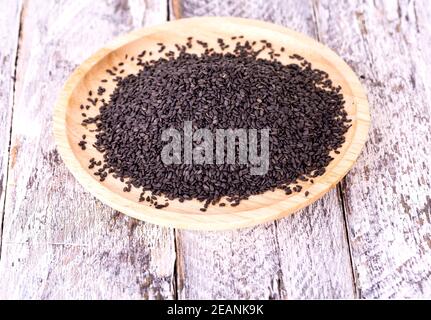 The Close up of black sesame seed on wooden plate Stock Photo