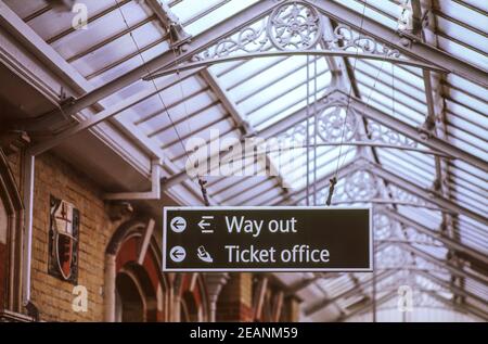 A hanging sign for Way Out and Ticket Office at Lewes train station in East Sussex, England, UK. Stock Photo