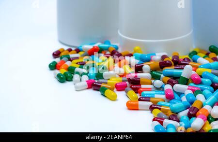 Selective focus on colorful antibiotic capsule pills on blur plastic drug bottle. Antibiotic drug resistance concept. Pharmaceutical industry. Healthcare and medicine. Pharmaceutical manufacturing. Stock Photo