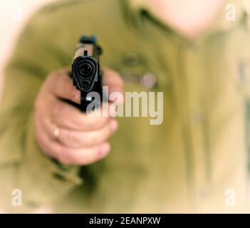 Man pointing gun at the target with one Hand Stock Photo