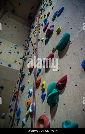 climbing wall with different colored handles in a modern gym Stock Photo