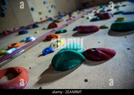 climbing wall with different colored handles in a modern gym Stock Photo