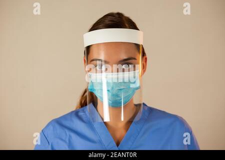 Caucasian female with attached face shield with light background. Stock Photo
