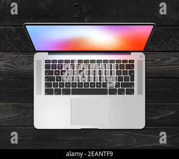 Open laptop top view with colorful screen, isolated on black wood background. 3D render Stock Photo