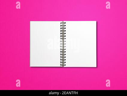 Blank open spiral notebook isolated on pink Stock Photo