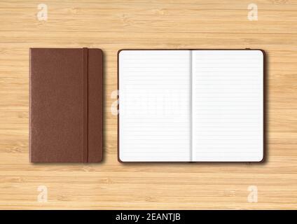 Dark leather closed and open lined notebooks on wooden background Stock Photo