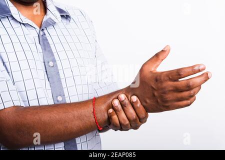 black man holds his wrist hand injury, feeling pain Stock Photo