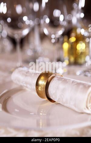 Vintage ring fixed on a napkin. The view from the top. Concept of table setting for the holiday. Glasses out of focus. Stock Photo