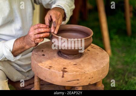 Craftsman hand making pottery from clay on potters wheel Stock Photo