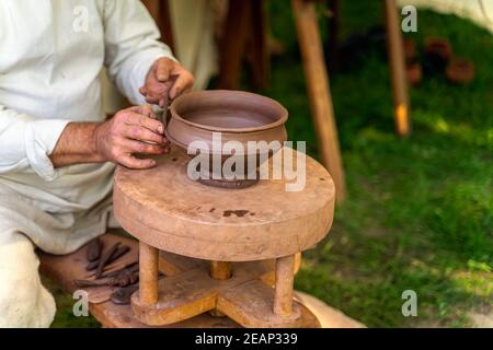 Craftsman hand making pottery from clay on potters wheel Stock Photo