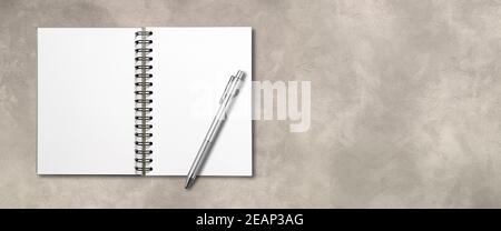 Blank open spiral notebook and pen isolated on concrete banner Stock Photo
