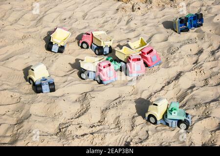 Huge sandpit with many toy dumper trucks for children's outdoor play in Godstone Farm, Surrey Stock Photo
