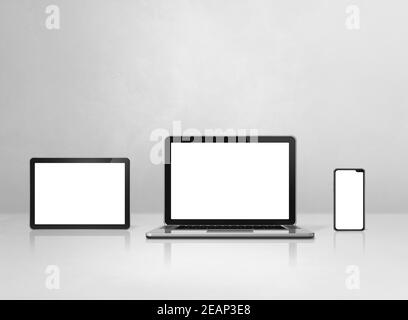 Laptop, mobile phone and digital tablet pc on white concrete office desk Stock Photo
