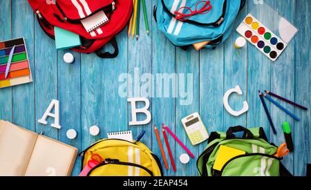 Colourful children schoolbags on wooden floor Stock Photo