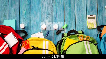 Colourful children schoolbags on wooden floor Stock Photo