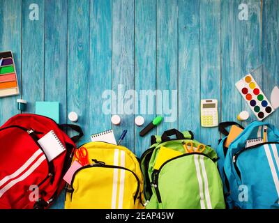 Colourful children schoolbags on wooden floor Stock Photo