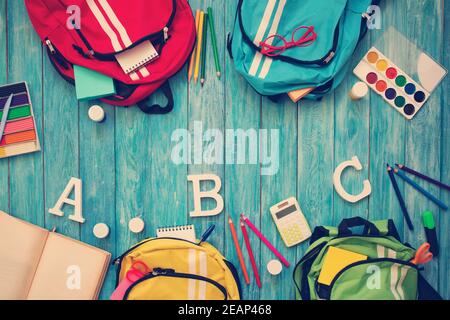 Colourful children schoolbags on wooden floor Stock Photo