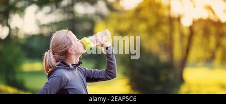 Young woman running on the field near seaside at sunset Stock Photo