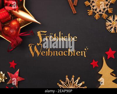 German words joyful Christmas with golden and red Christmas items Stock Photo